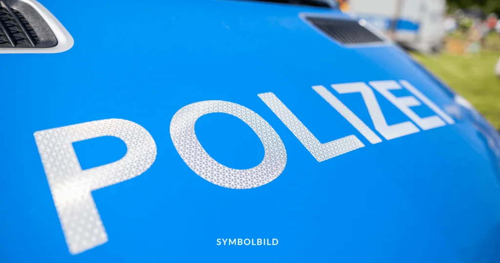 Das Bild zeigt eine Nahaufnahme des Wortes „POLIZEI“, das in weißen Großbuchstaben auf einem blauen Hintergrund geschrieben ist (Motorhaube). Polizei Solingen Symbolbild