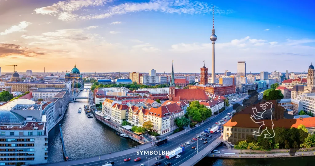 Das Bild zeigt eine beeindruckende Panoramaansicht von Berlin. Zu sehen ist die Skyline der Stadt mit markanten Gebäuden und dem Fluss Spree, der sich durch die Stadt schlängelt. Der Fernsehturm, eines der bekanntesten Wahrzeichen Berlins, ist deutlich sichtbar und deutet auf das zentrale Stadtgebiet hin. Die Architektur reicht von modern bis traditionell und spiegelt die reiche Geschichte und Entwicklung Berlins wider. Symbolbild Streik in Berliner Kitas führt zu Betreuungsnotstand für Eltern