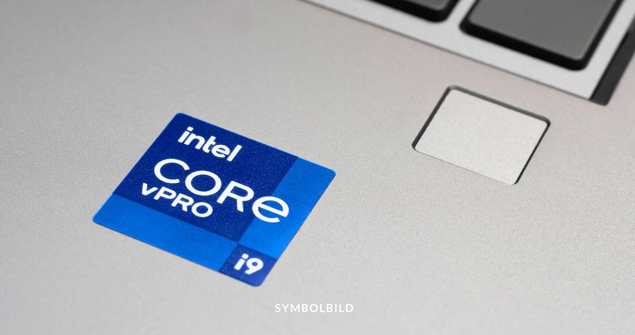 Das Bild zeigt eine Nahaufnahme der Oberfläche eines Laptops mit einem Aufkleber, der darauf hinweist, dass er mit einem “Intel CORE vPRO i9”-Prozessor betrieben wird. Der Aufkleber ist blau mit weißer und hellblauer Schrift und befindet sich in der Nähe der Ecke des Handballenbereichs des Laptops, neben dem Trackpad. SYMBOLBILD Intel verschiebt den Bau der Chipfabrik in Magdeburg um 2 Jahre. Staatliche Hilfen von 9,9 Milliarden Euro und die europäische Halbleiterstrategie sind betroffen.