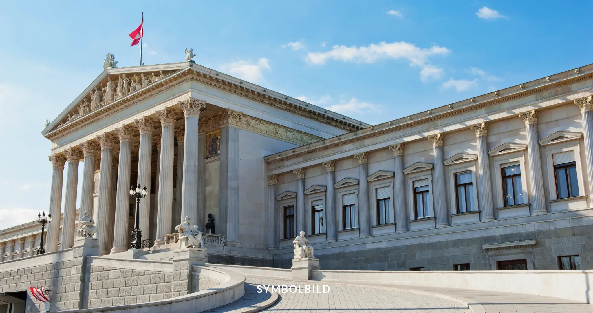 Das Bild zeigt das österreichische Parlament in Wien, ein markantes Gebäude im neoklassizistischen Stil. Die Vorderseite des Gebäudes ist mit hohen korinthischen Säulen und einer kunstvoll gestalteten Frontfassade verziert, die verschiedene Skulpturen und Reliefs zeigt. Auf dem Dach weht die österreichische Flagge. Symbolbild FPÖ Wahlsieg bei der Nationalratswahl in Österreich