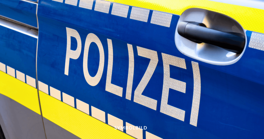 Das Bild zeigt die Seite eines Polizeiautos mit dem Wort “POLIZEI” in großen weißen Buchstaben auf einem blauen Hintergrund. Darunter befindet sich ein gelber Streifen mit schwarzen Rändern, der Teil des typischen Farbschemas deutscher Polizeifahrzeuge ist. SYMBOLBILD Brutaler Angriff im Märkischen Viertel in Berlin