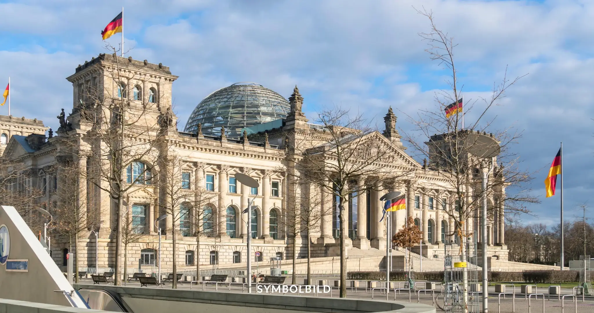 Das Bild zeigt das Reichstagsgebäude in Berlin, Deutschland. Es ist ein historisches Gebäude, das als Sitz des Deutschen Bundestages dient. Das Gebäude ist bekannt für seine markante Glaskuppel, die von Sir Norman Foster entworfen wurde. Auf dem Bild sind mehrere deutsche Flaggen zu sehen, die auf dem Gebäude und in der Umgebung wehen. SYMBOLBILD Sicherheitspaket im Bundestag