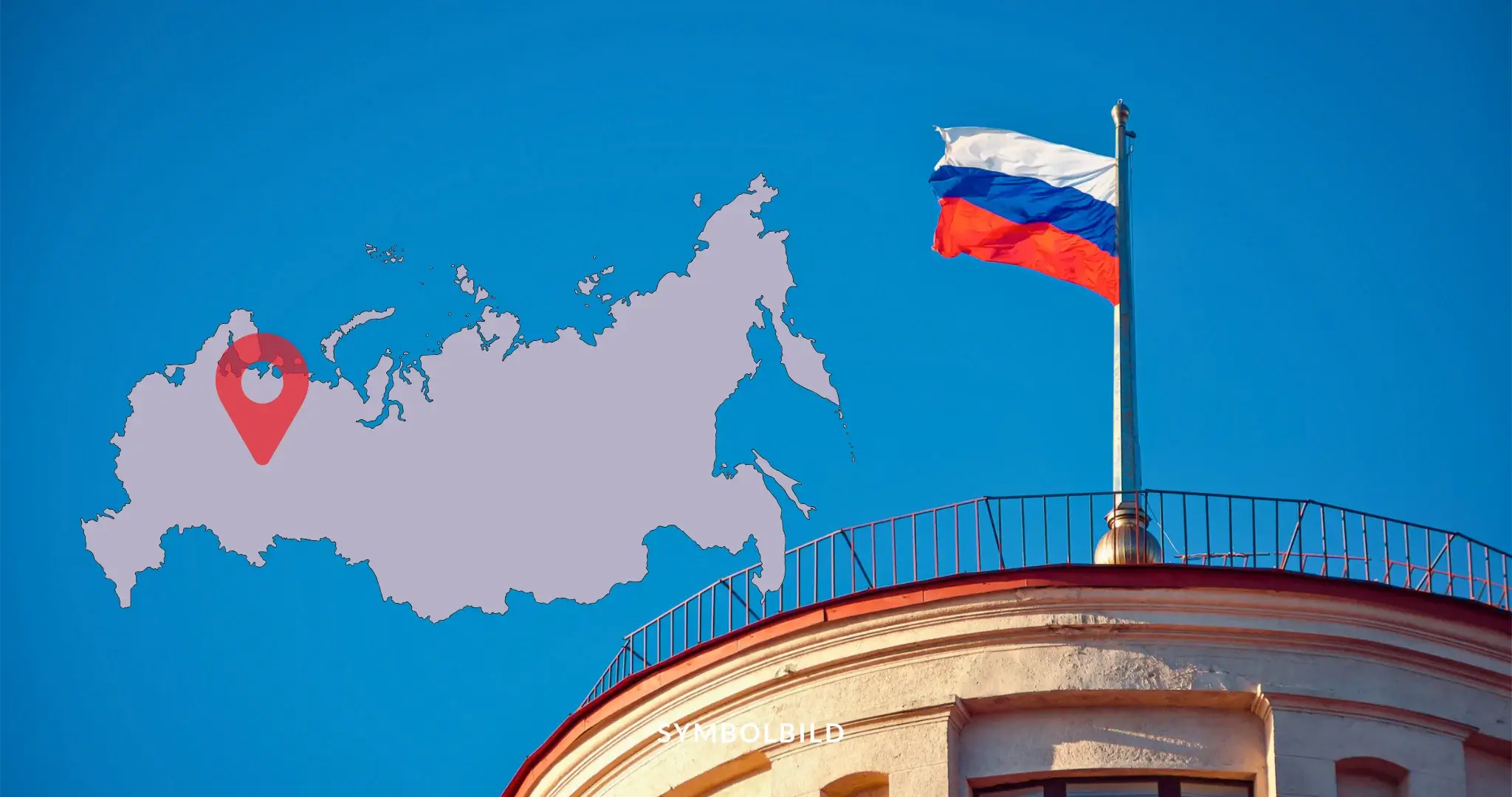 Das Bild zeigt eine russische Flagge, die auf einem Gebäude weht. Im Hintergrund ist eine Karte von Russland zu sehen, auf der ein roter Standortmarker platziert ist. Der Standortmarker befindet sich im westlichen Teil Russlands. SYMBOLBILD Russland Deutsch-Russe wegen angeblicher Sabotagepläne festgenommen